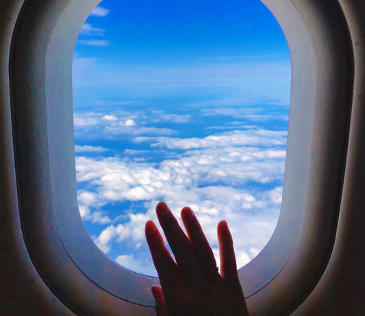 機窓から望む空と雲。左手薬指のmarumaru ring。